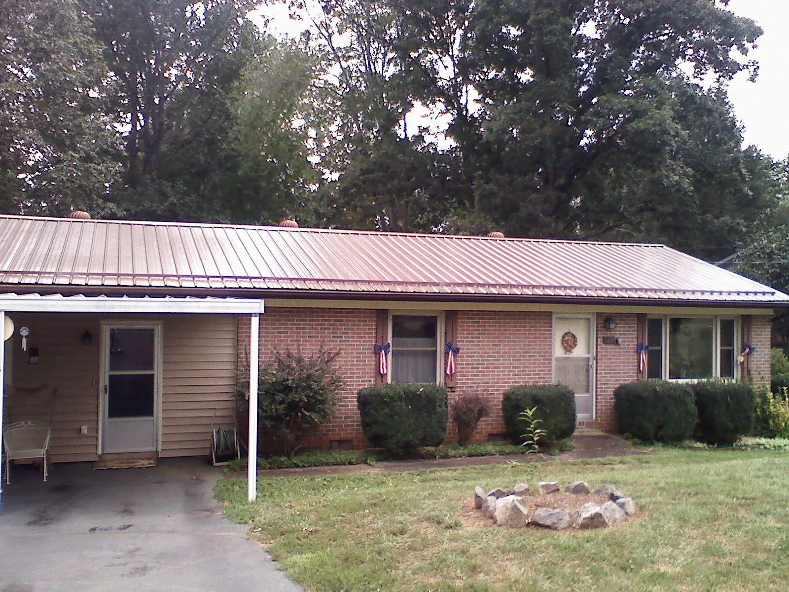 Bronze metal roof and carport on a brick ranch home — Roof Repair work by our crew in Lynn