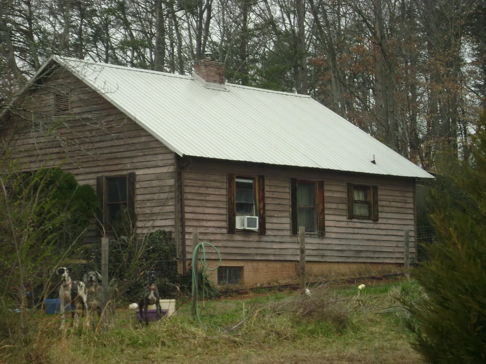 White metal roof on an old wood sided farmhouse, from a Metal Roof Installation job in Lynn